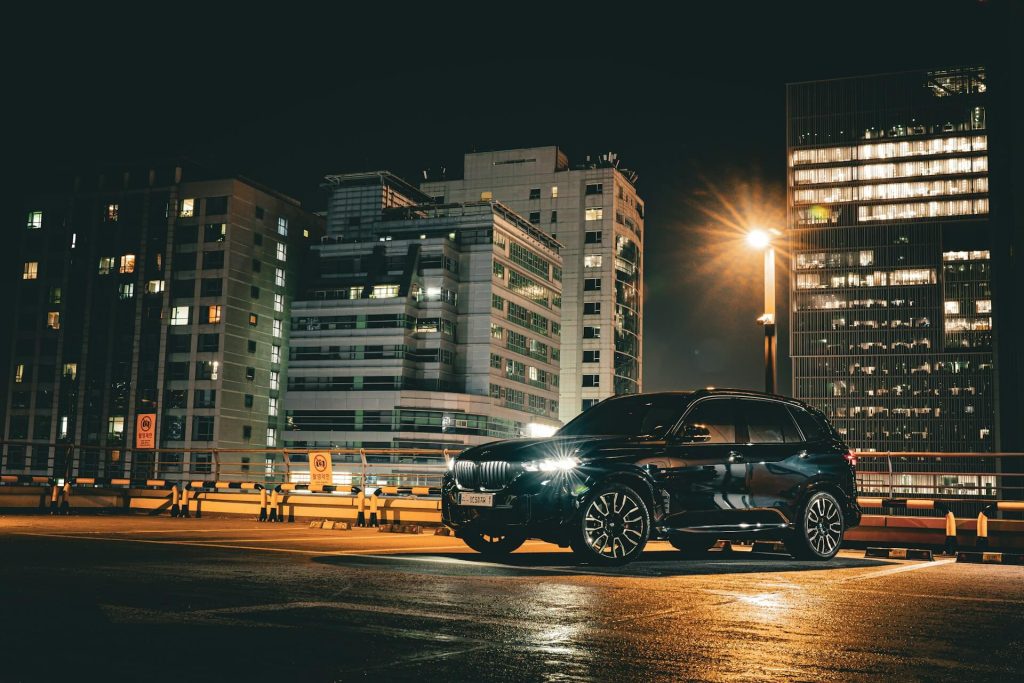 black bmw suv parked in city at night